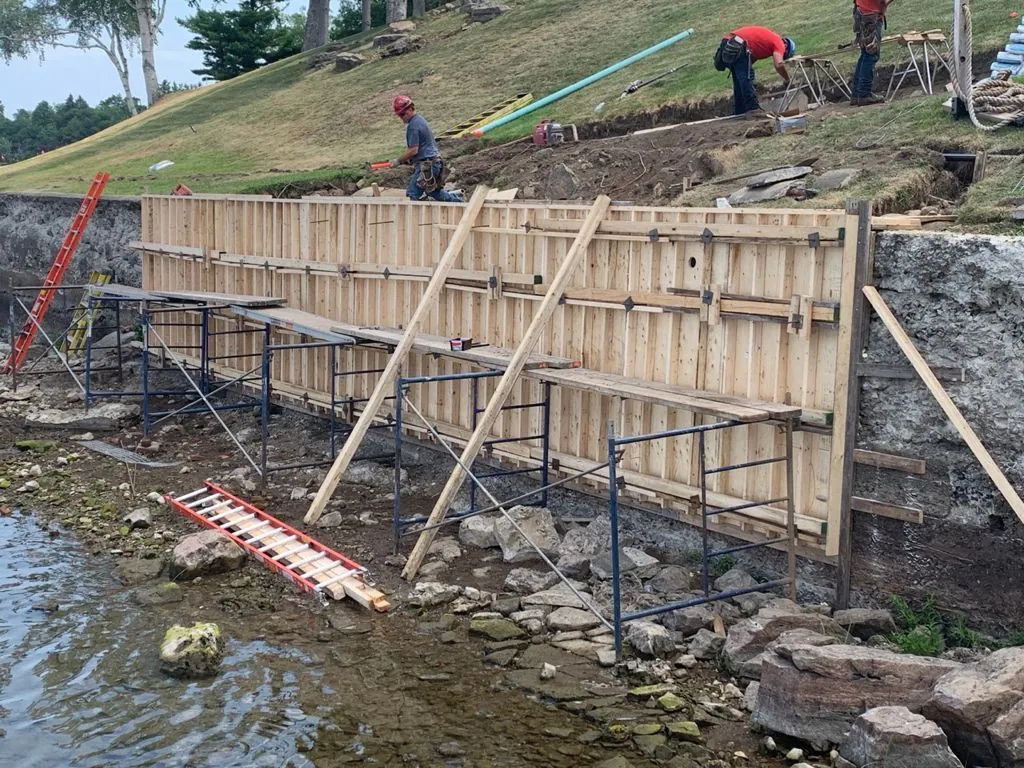 Ouvrier inspectant la fondation en béton d’une maison résidentielle.
