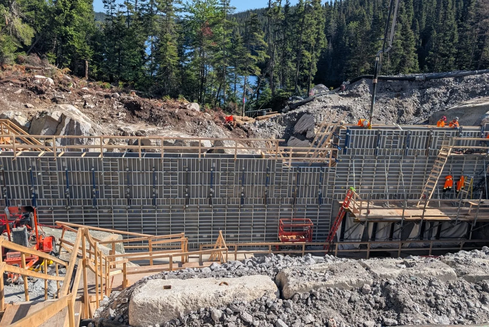 Charpentiers assemblant un coffrage de bois avant une coulée de béton.